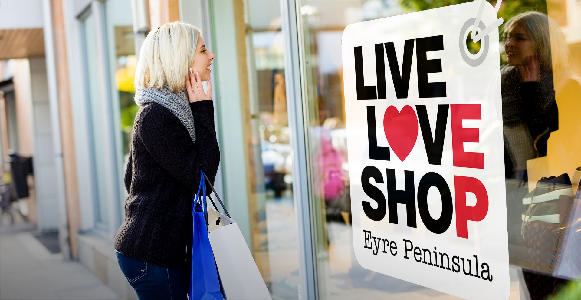 Female looks into shop window with Live Love Shop EP sign in window